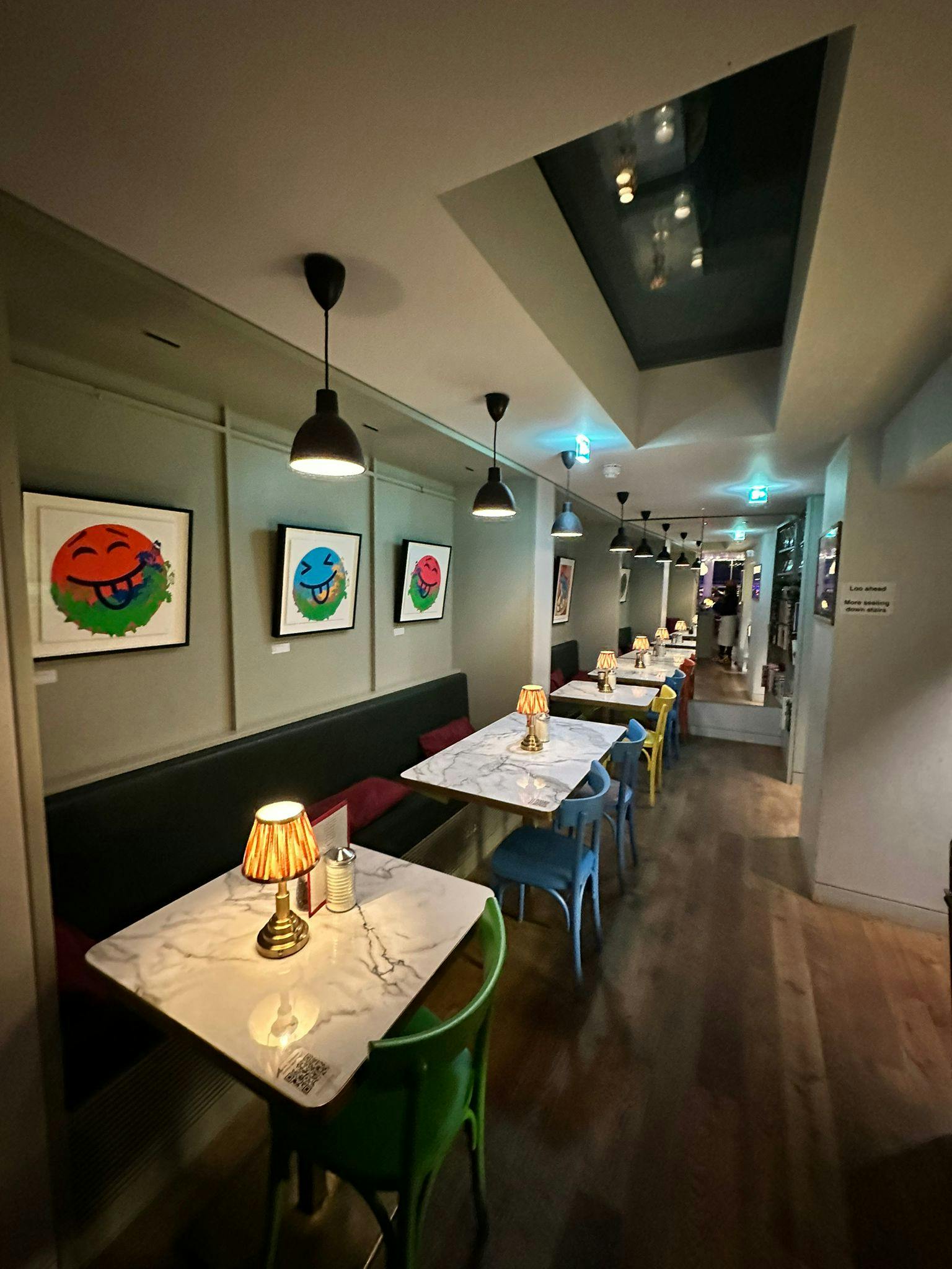 Modern event space at Sam's Cafe with vibrant artwork, perfect for intimate gatherings.