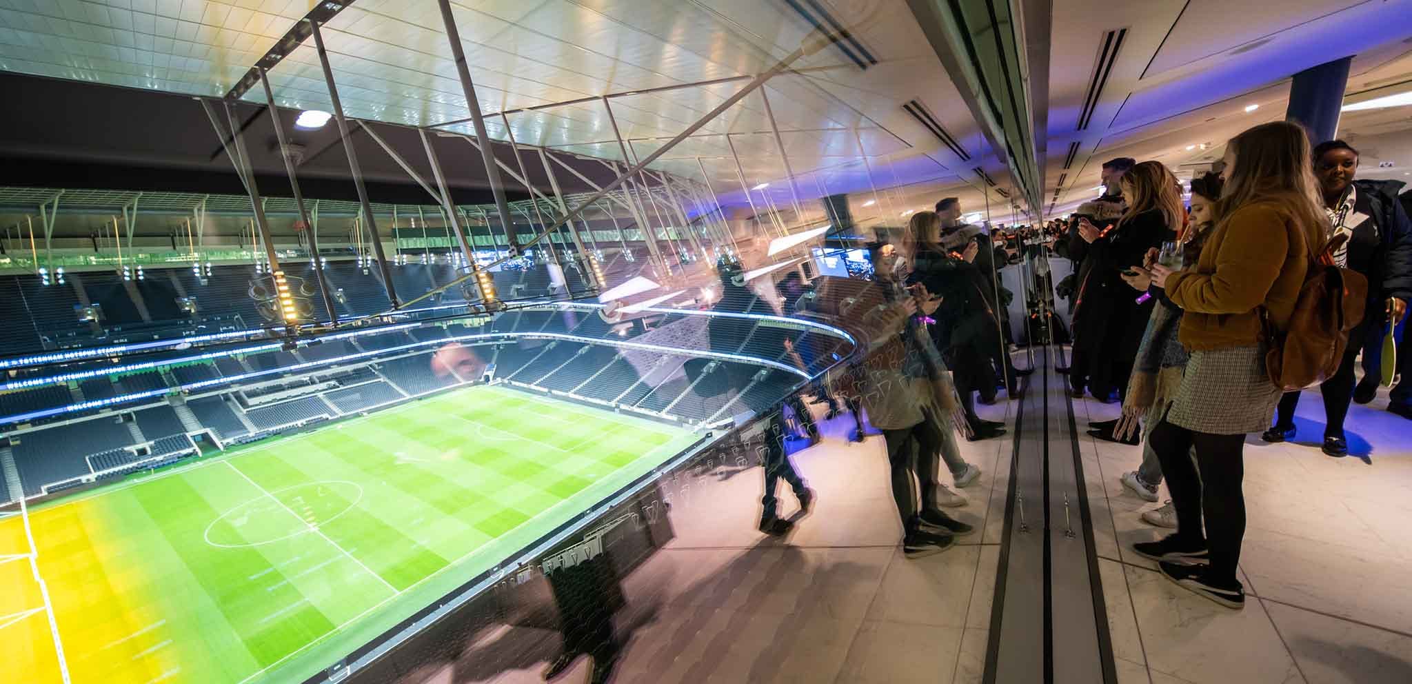 "Modern event space at Tottenham Hotspur Stadium with glass barriers for corporate gatherings."