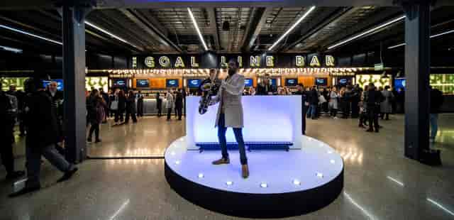 Saxophonist performing at Tottenham Hotspur Stadium's vibrant event space for networking.