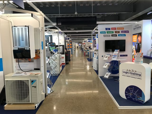 Exhibition hall at Tottenham Hotspur Stadium with vendor booths for networking event.