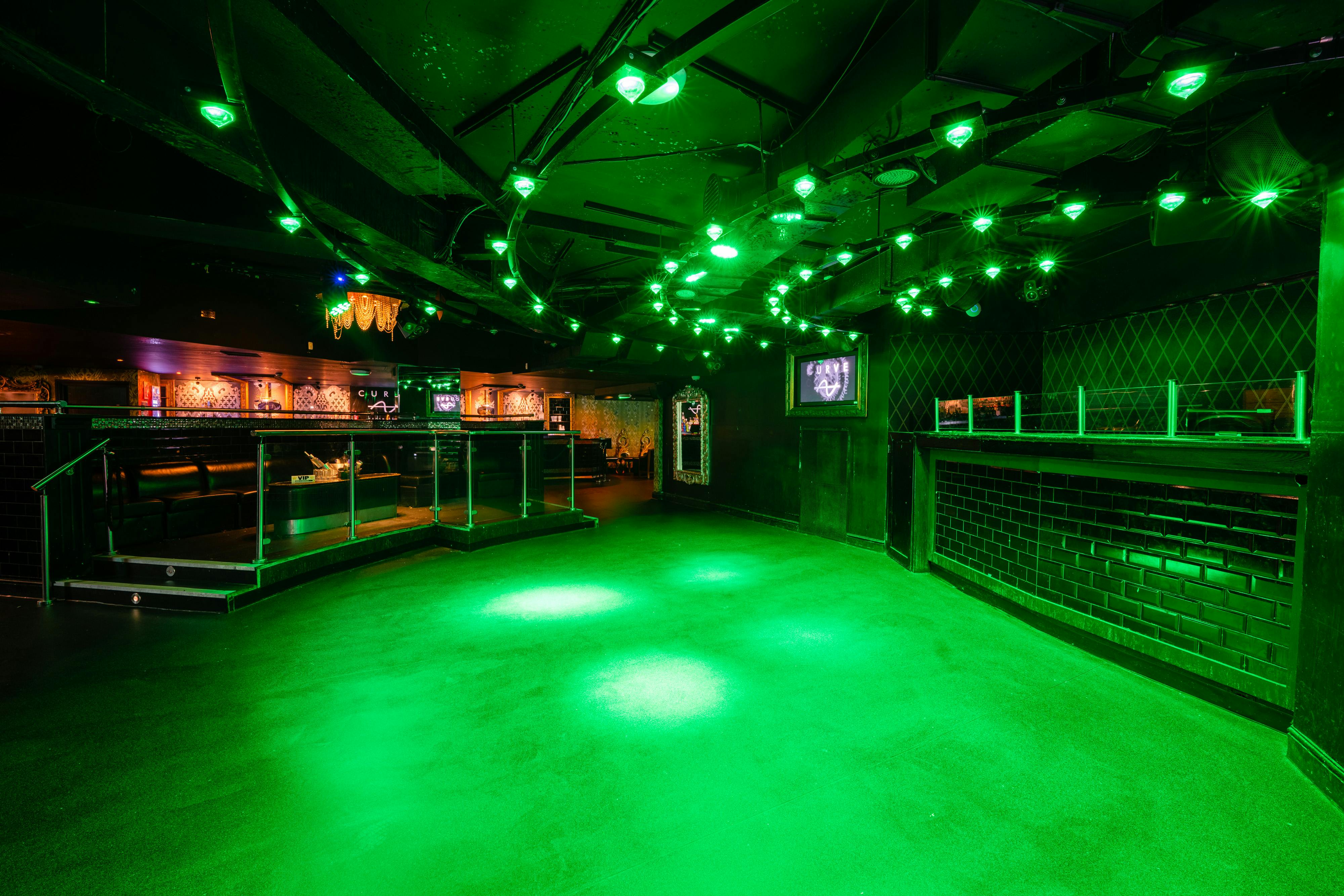 Modern event space Curve in Pryzm Brighton with vibrant green lighting for parties and networking.