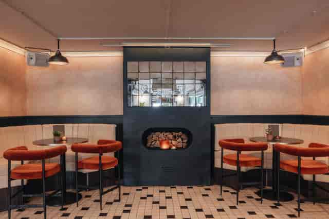 Stylish meeting space with cozy seating and unique fireplace for networking events.