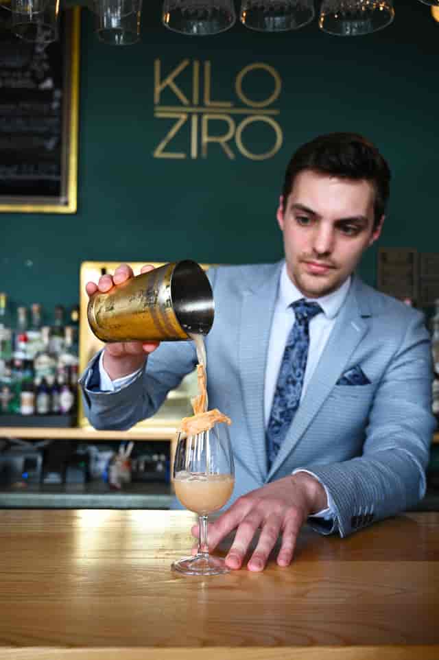 Skilled bartender pouring cocktail at KILO ZIRO venue for upscale events.