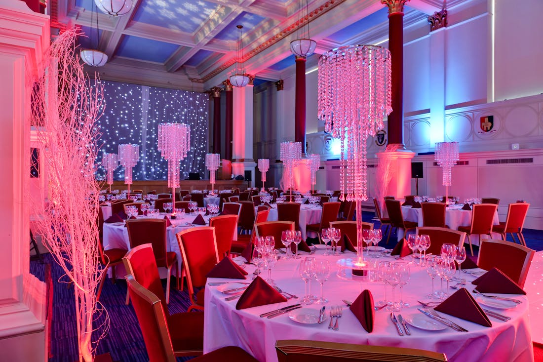 Elegant Christmas party setup at BMA House with pink lighting and tall centerpieces.