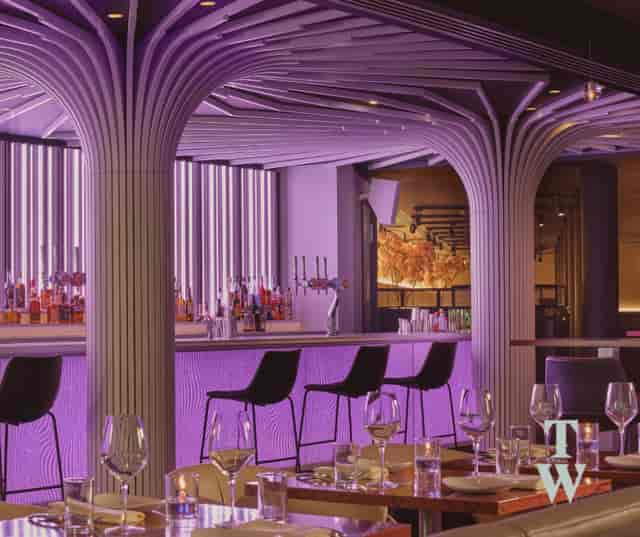 Modern event space at The Boothroyd, featuring a sleek bar and vibrant purple lighting.