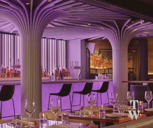 Modern event space at The Boothroyd, featuring a sleek bar and vibrant purple lighting.