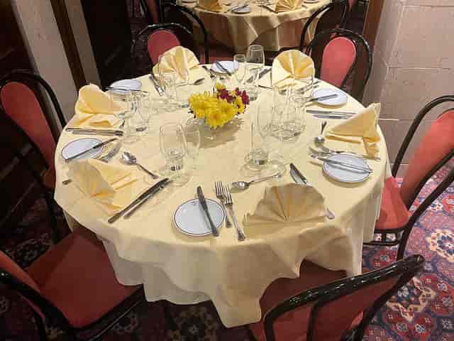 Elegant round dining table set for Christmas event at Bolton's Restaurant.