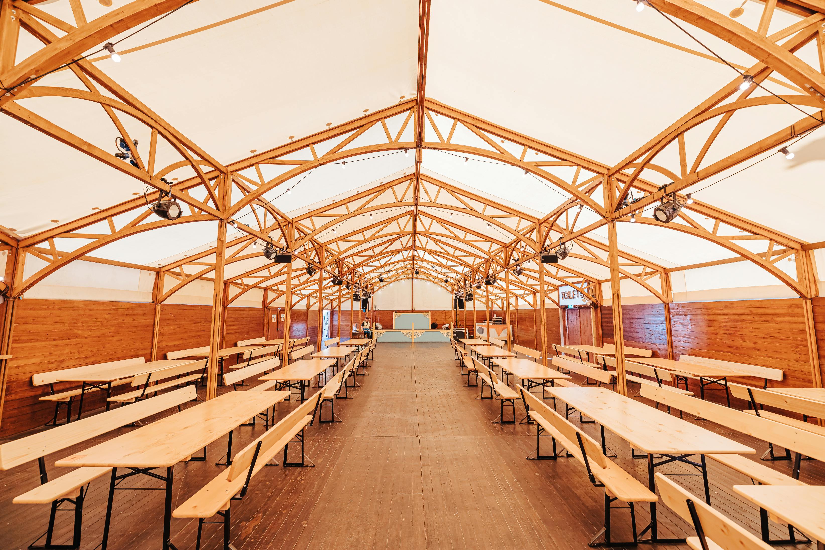 Spacious wooden event venue with natural light, ideal for workshops and networking.