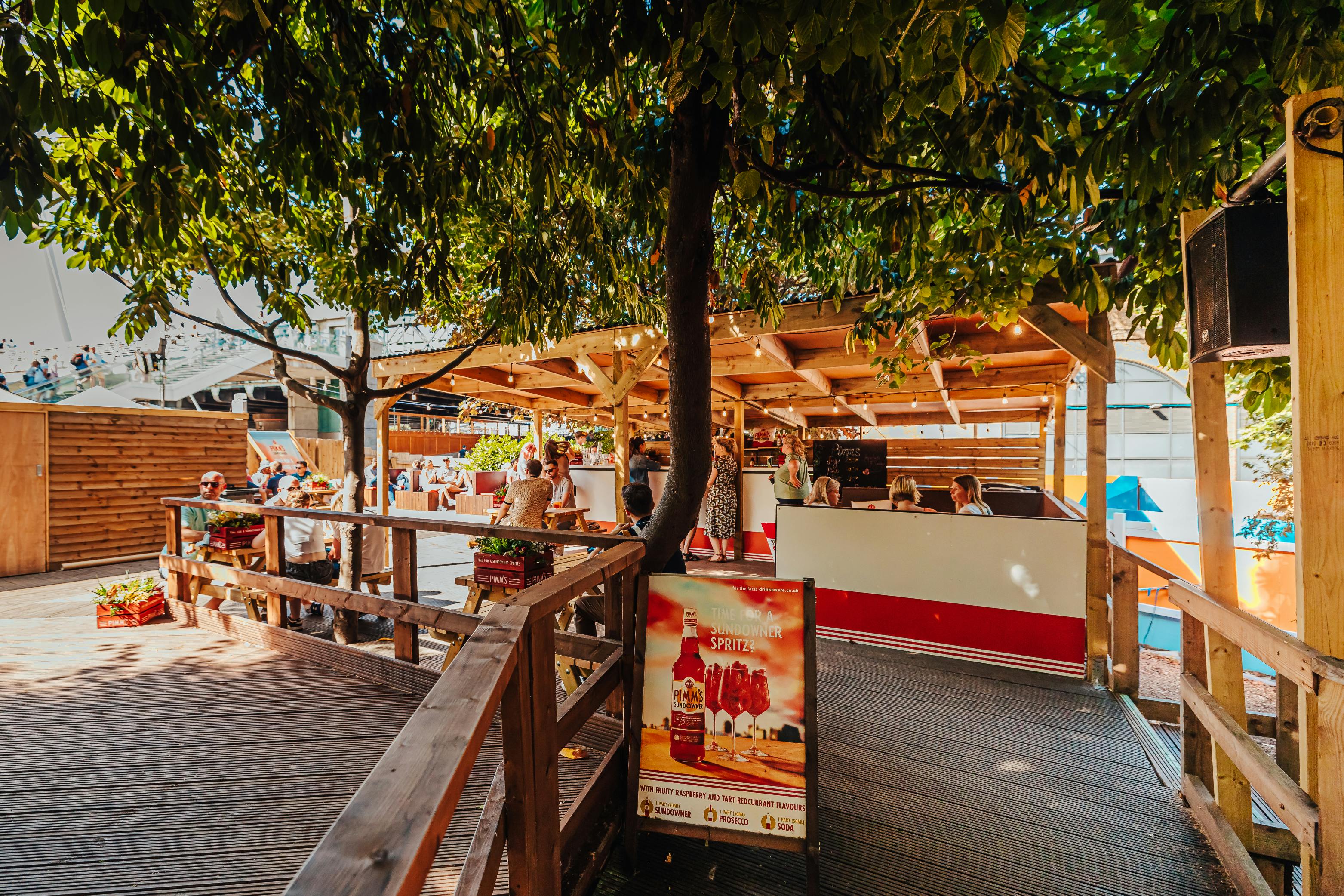 Vibrant outdoor event space with wooden deck, ideal for casual gatherings and networking.