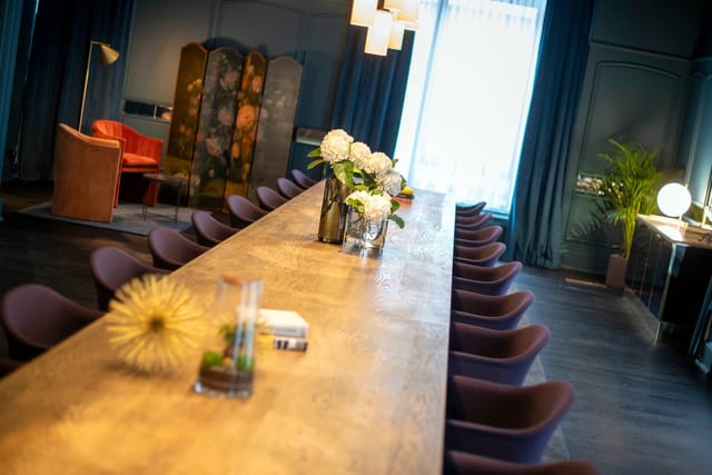 Stylish meeting space with wooden table and elegant decor in Renaissance Brussels Hotel.