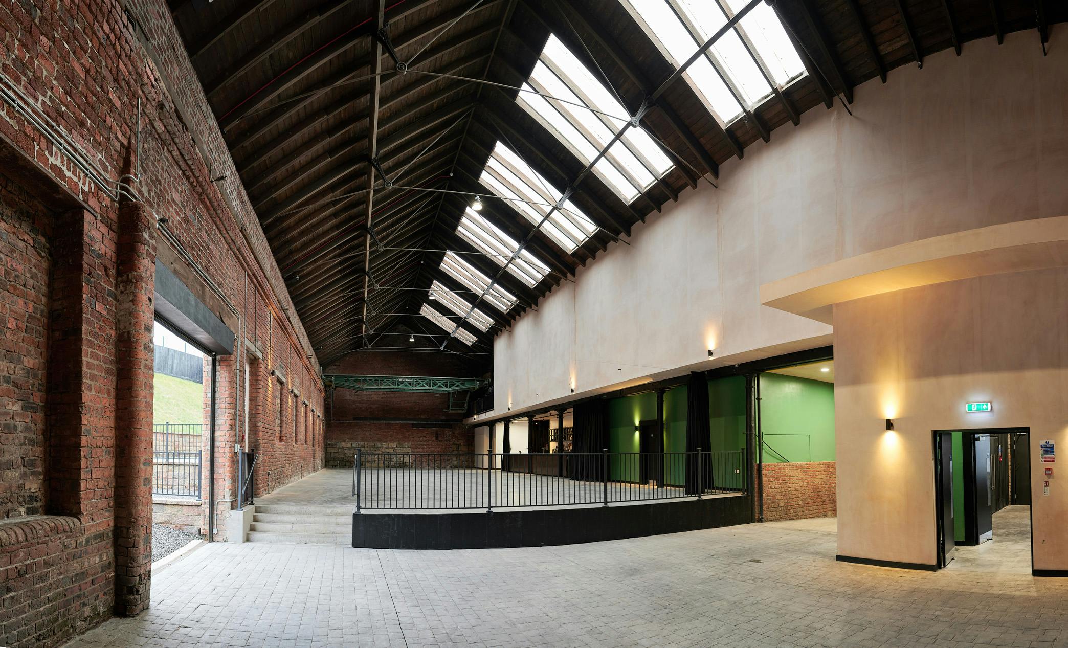 Spacious industrial venue with exposed brick, ideal for conferences and workshops.