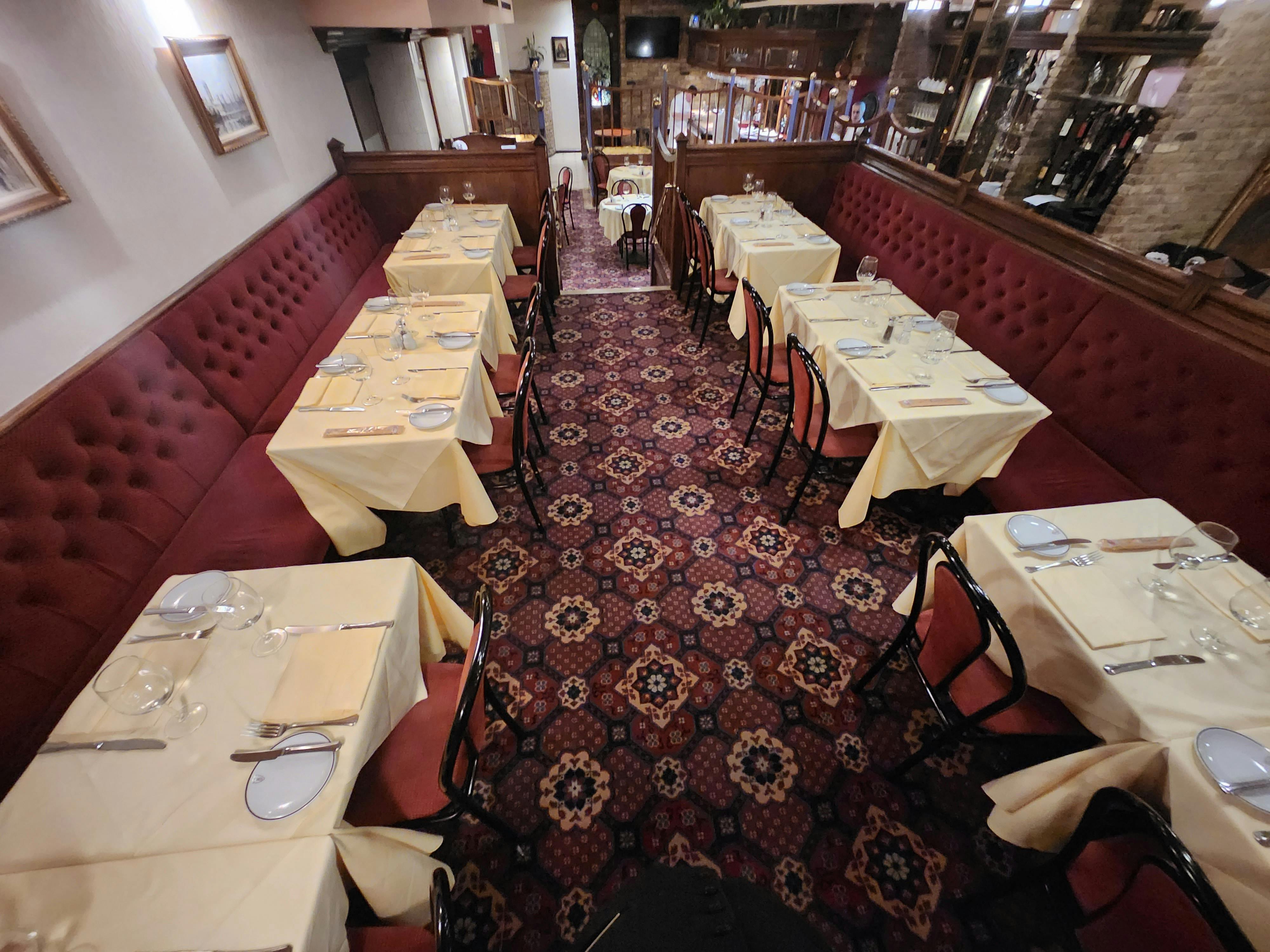 Semi-private dining space in Bolton's Restaurant with yellow tablecloths for events.