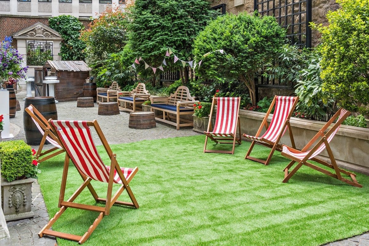 Charming outdoor courtyard with striped deck chairs for summer gatherings and networking events.