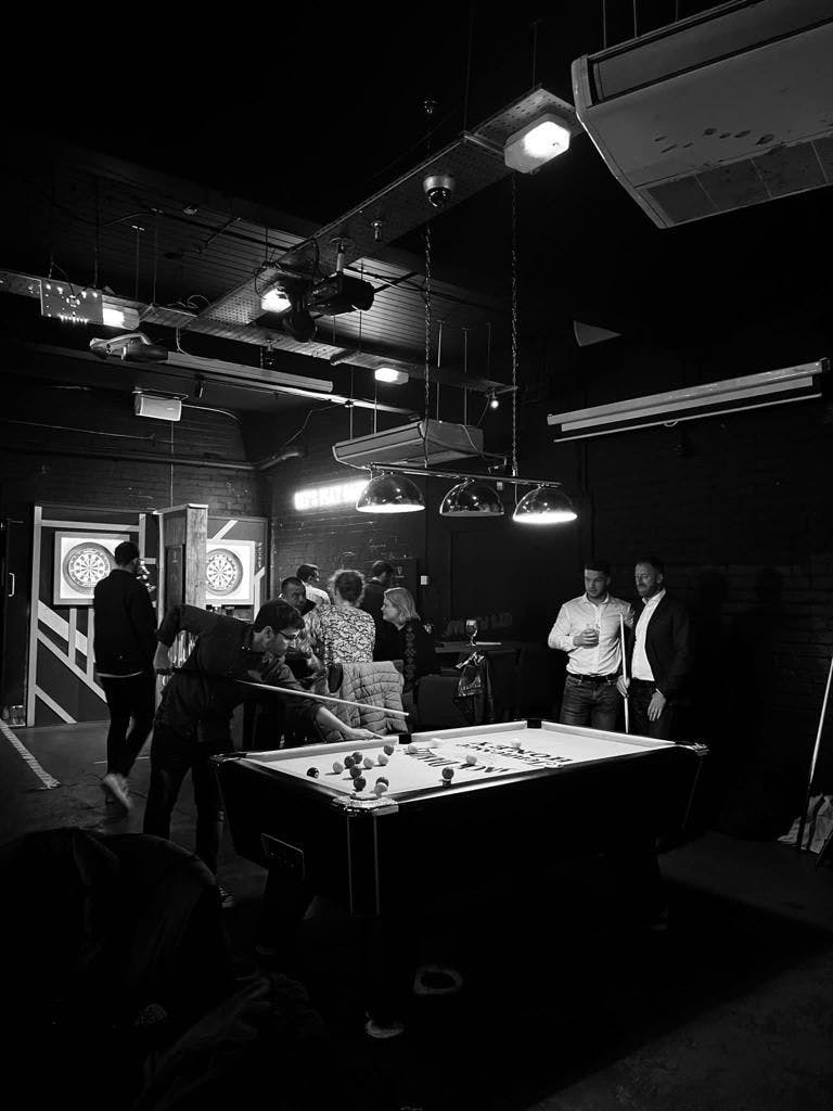 Vibrant social event space with pool table for networking and team-building activities.