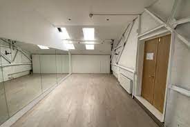 Industrial dance studio with mirrors for fitness classes and movement workshops.