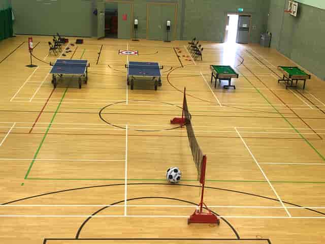 Versatile sports hall in Basildon for tournaments, featuring table tennis and soccer setup.