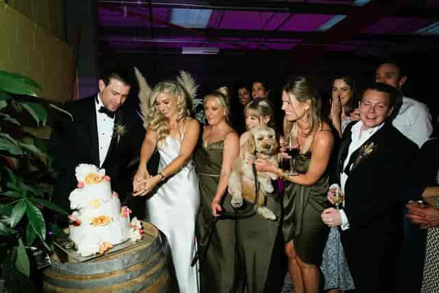 Industrial-chic wedding reception at Renegade Urban Winery with rustic decor and cake cutting.