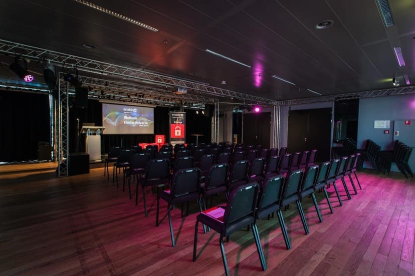 Atriumzaal event space with black chairs, ideal for conferences and presentations.