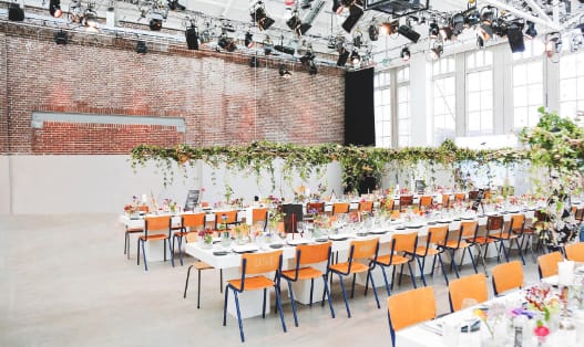 Event space in Hallen Studios with long tables and floral centerpieces for gatherings.
