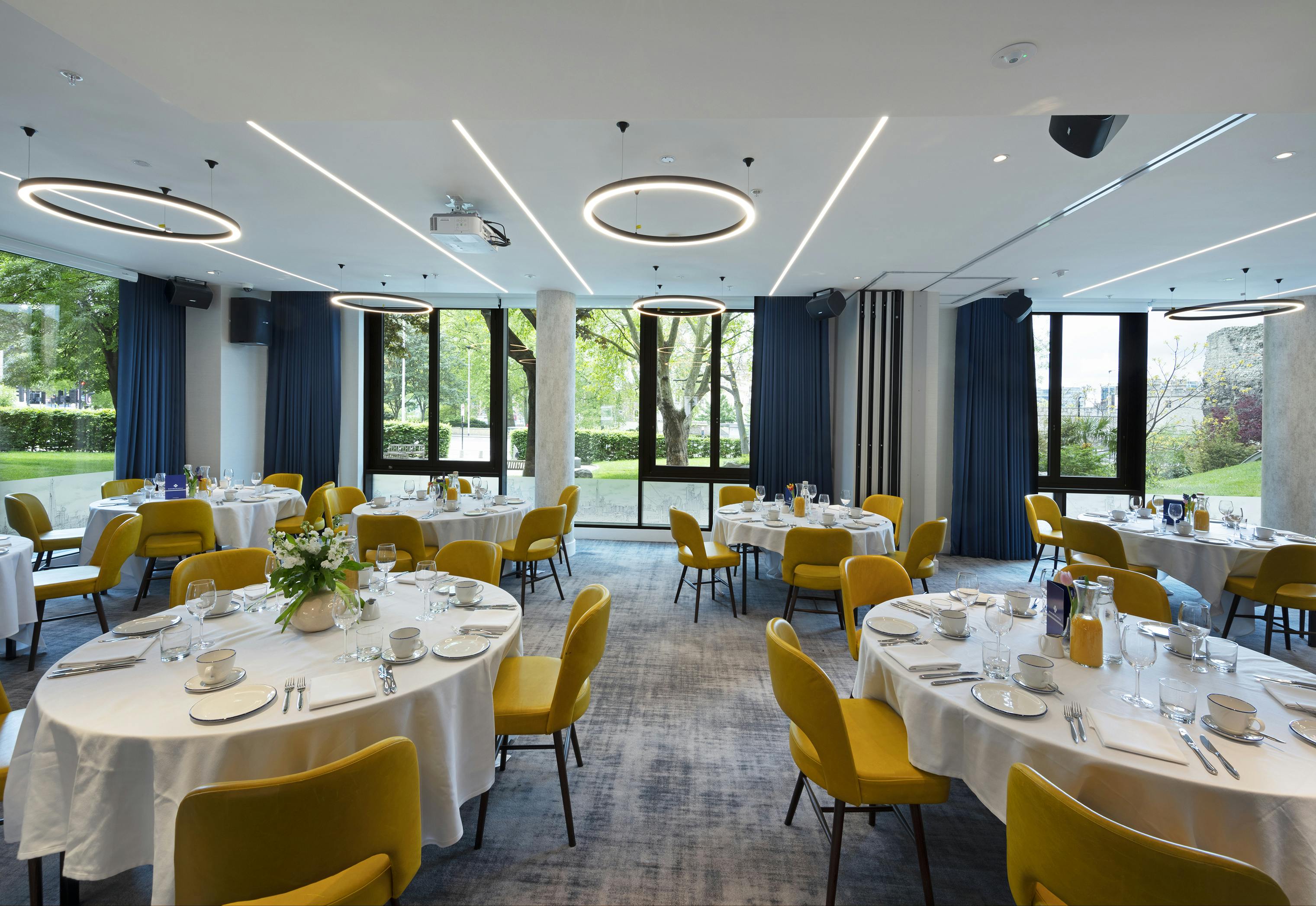 Thames Suite event space with elegant round tables, ideal for meetings and gatherings.