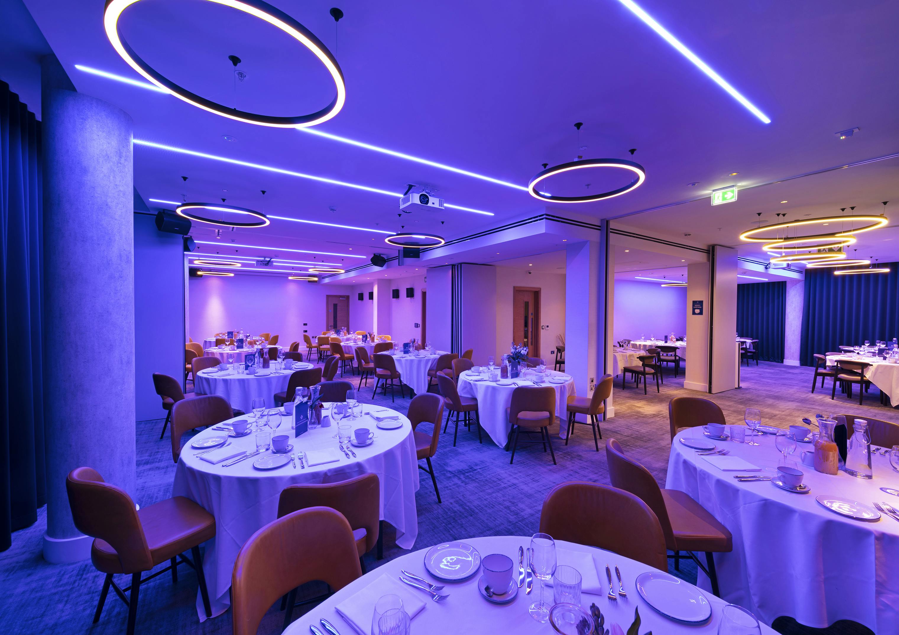 Royal Suite event space with elegant round tables and ambient purple lighting.