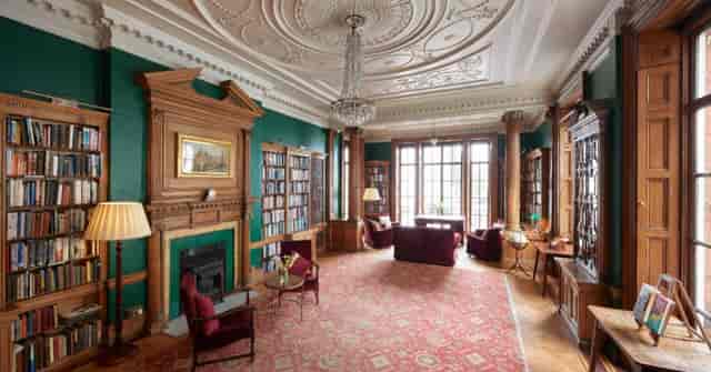Elegant library meeting space with wood paneling, ideal for gatherings and discussions.