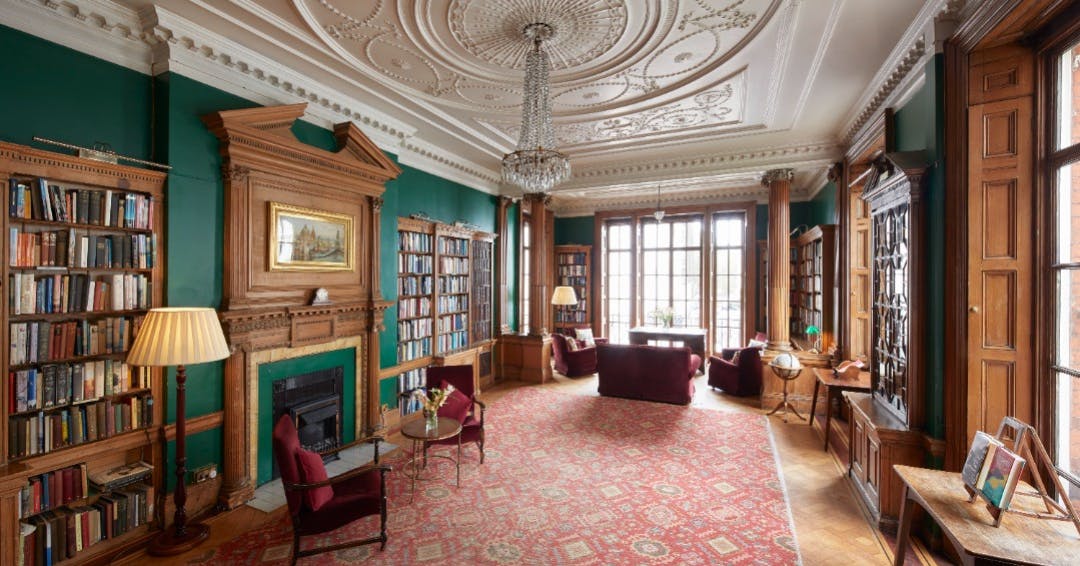 Elegant library meeting space with wood paneling for networking events and conferences.