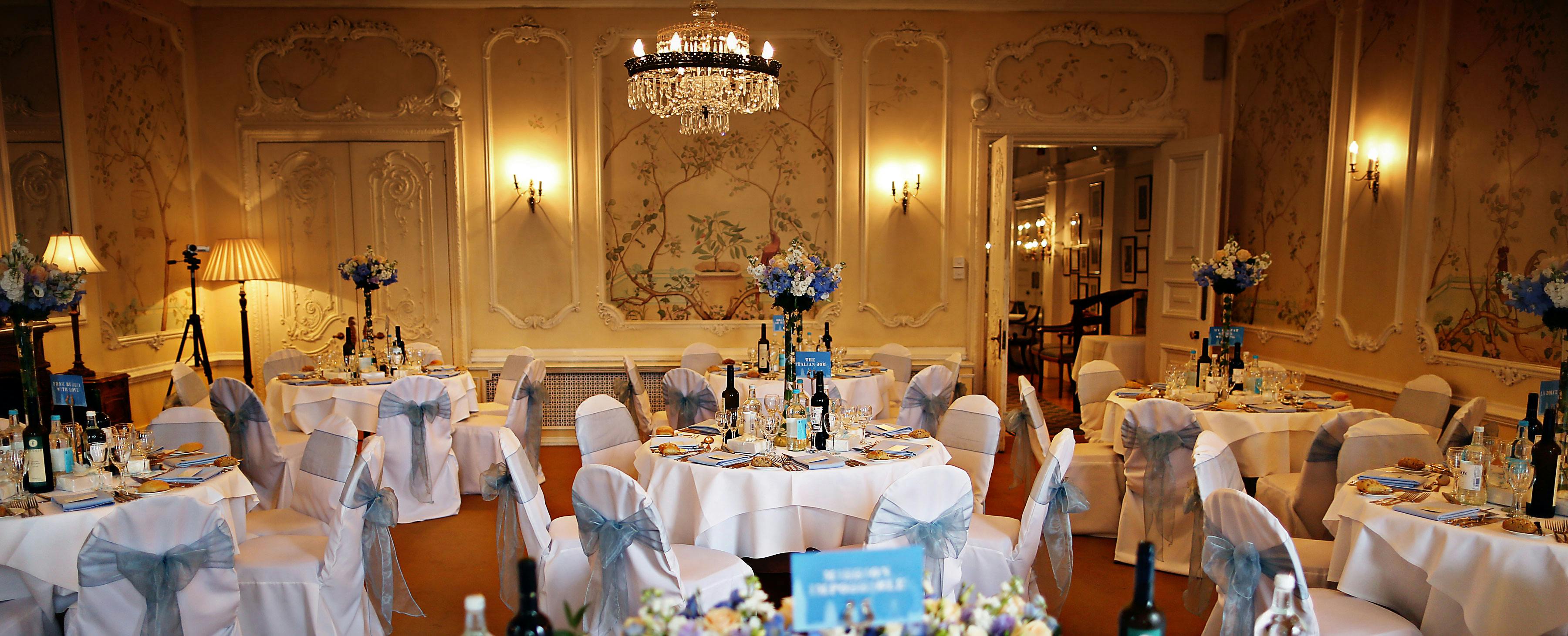 Elegant event space with round tables and floral centerpieces for weddings and corporate events.