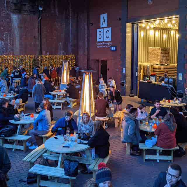 Outdoor event space at Alphabet Brewing Company with cozy picnic tables for gatherings.