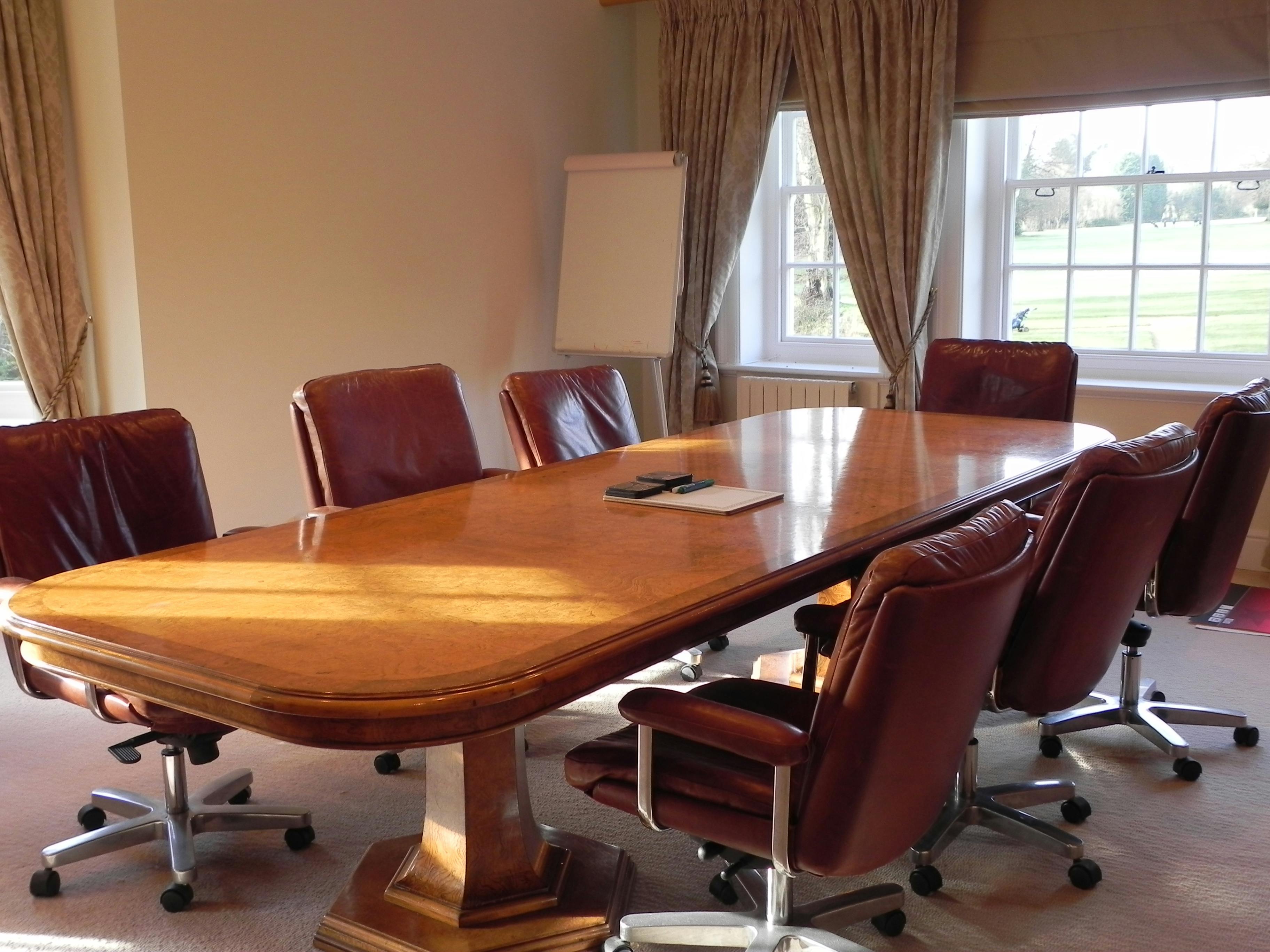 Conference room at Badgemore Park with polished wooden table, ideal for meetings and presentations.