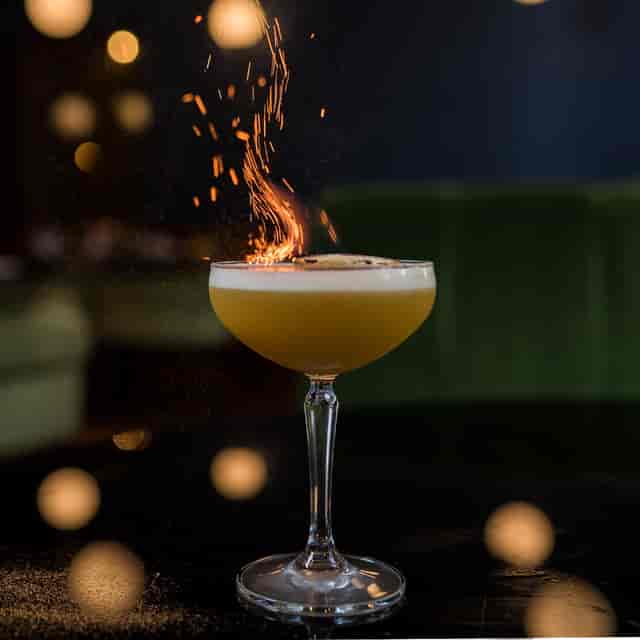 Vibrant cocktail with flame at Masons Restaurant Bar for events and networking.