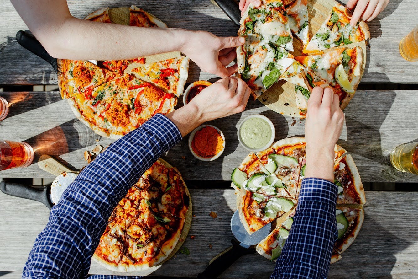 Vibrant team-building event at The Bath Stable with diverse pizzas on display.