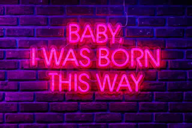 Private karaoke room with neon sign "Baby, I Was Born This Way" for themed events.