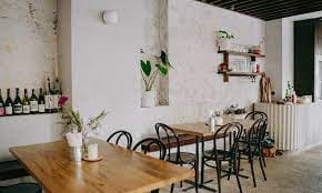 Private room in Restaurant Bouche, featuring warm wooden tables for intimate gatherings.