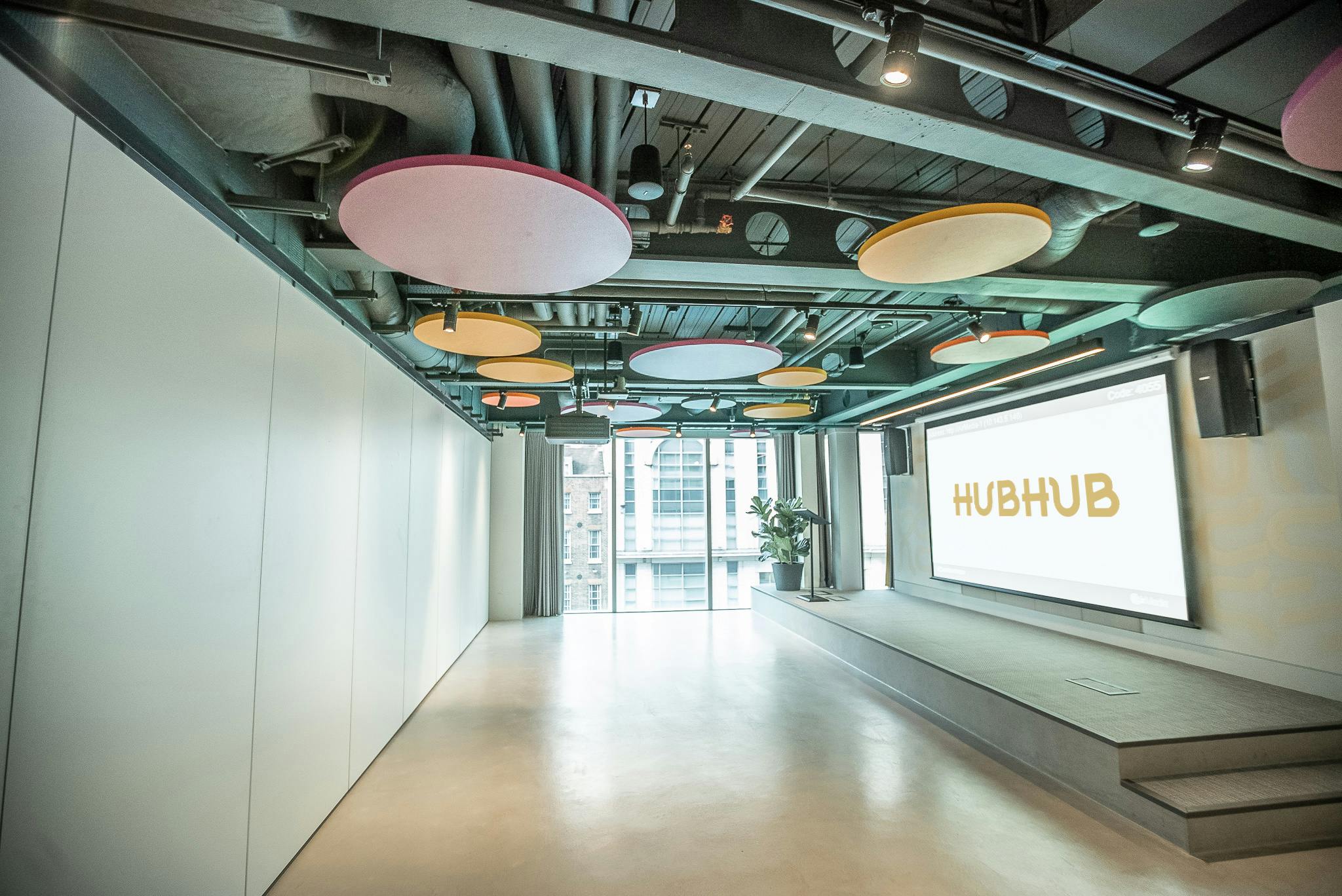 Modern event space with colorful acoustic panels, ideal for meetings and networking.