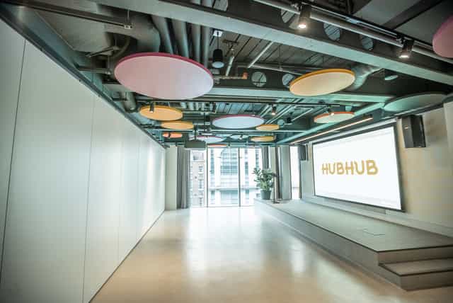 Modern event space with colorful acoustic panels, ideal for meetings and networking.