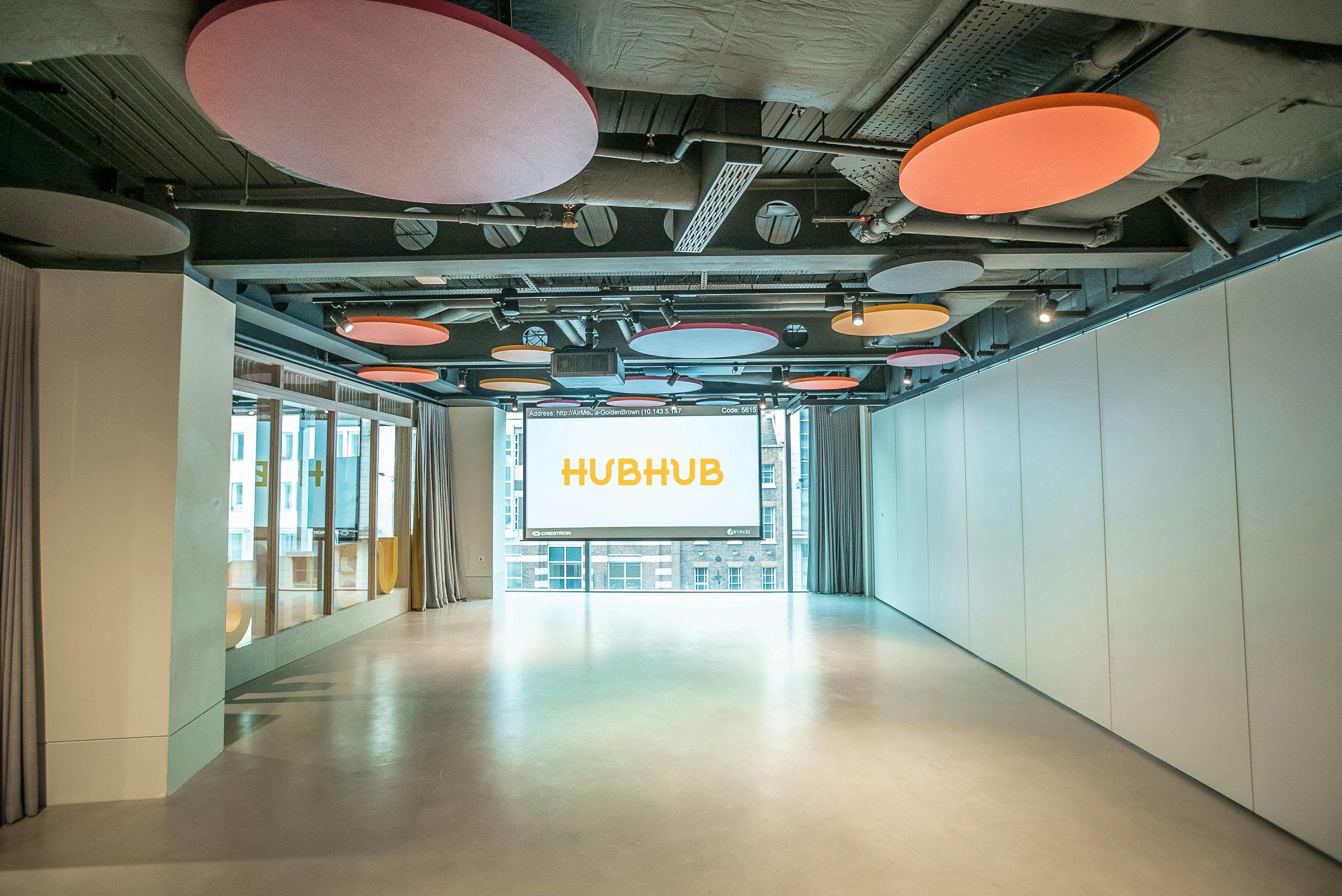Modern event space with bright acoustic panels for corporate meetings and workshops.