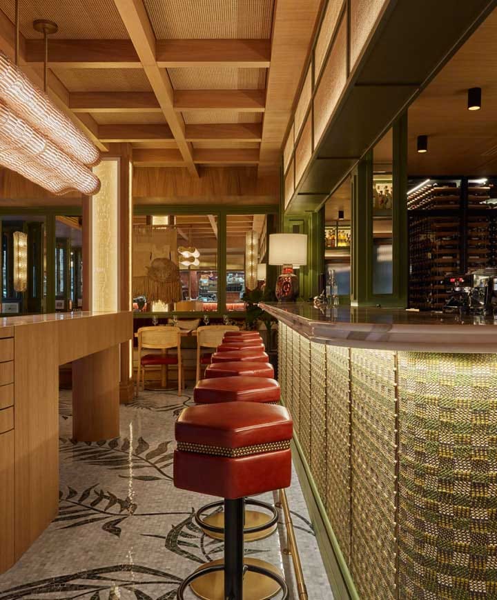 Stylish bar area in Vesper with warm wood tones, perfect for networking events.