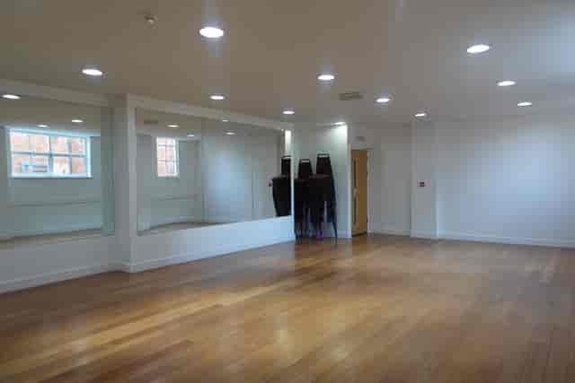 Versatile event space with polished wooden floors, ideal for meetings and workshops.