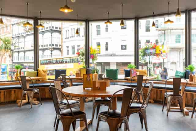 Bright event space with large windows, ideal for casual meetings and networking.