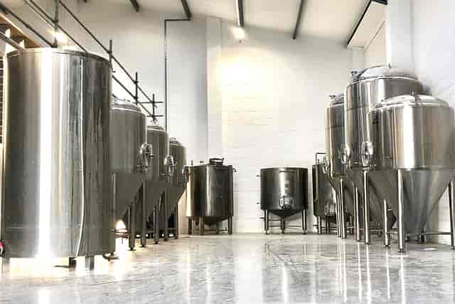 Modern brewery venue with stainless steel tanks for corporate events and team-building.