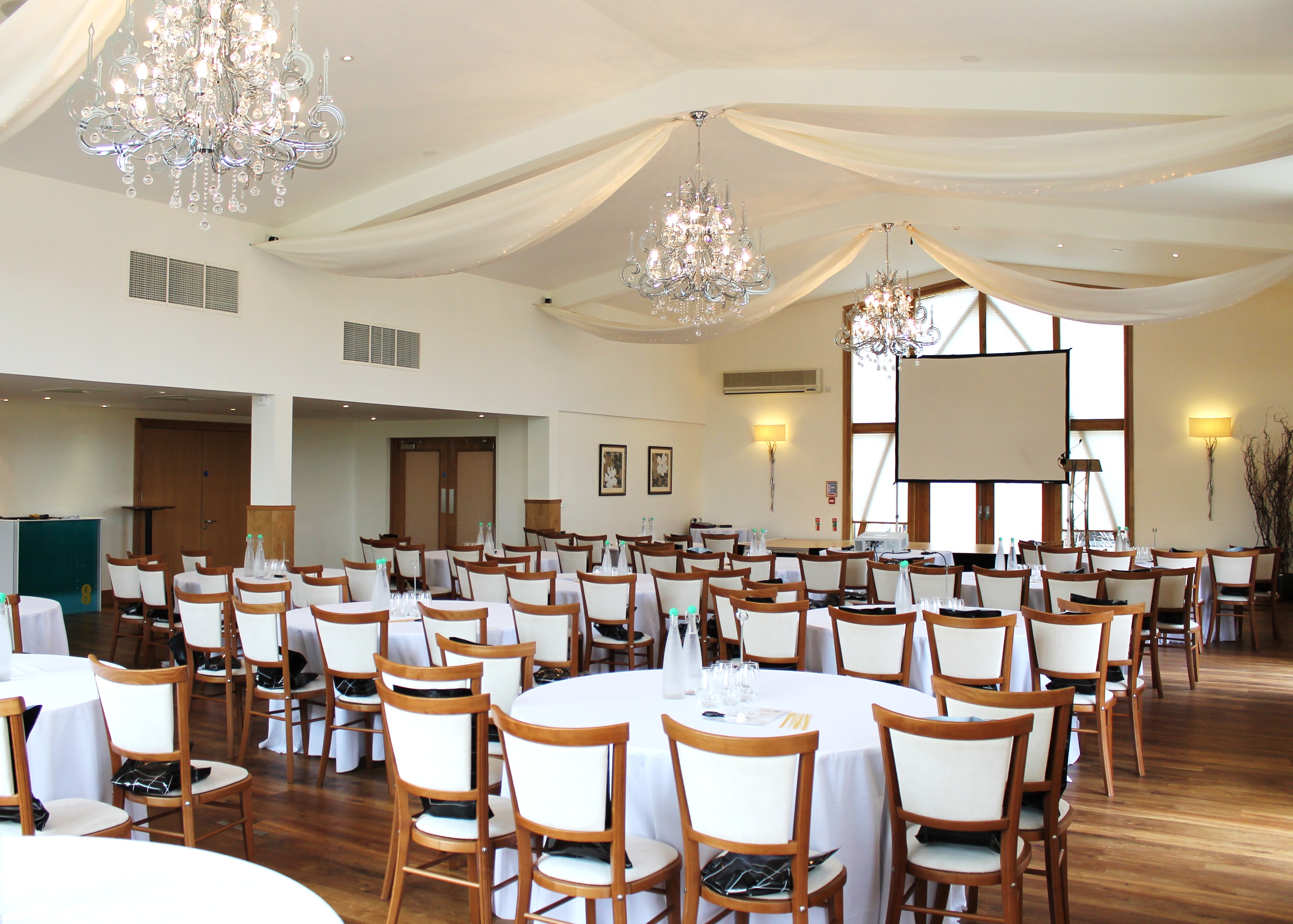 Mythe Barn event space with elegant chandeliers, ideal for corporate meetings and banquets. - Banner