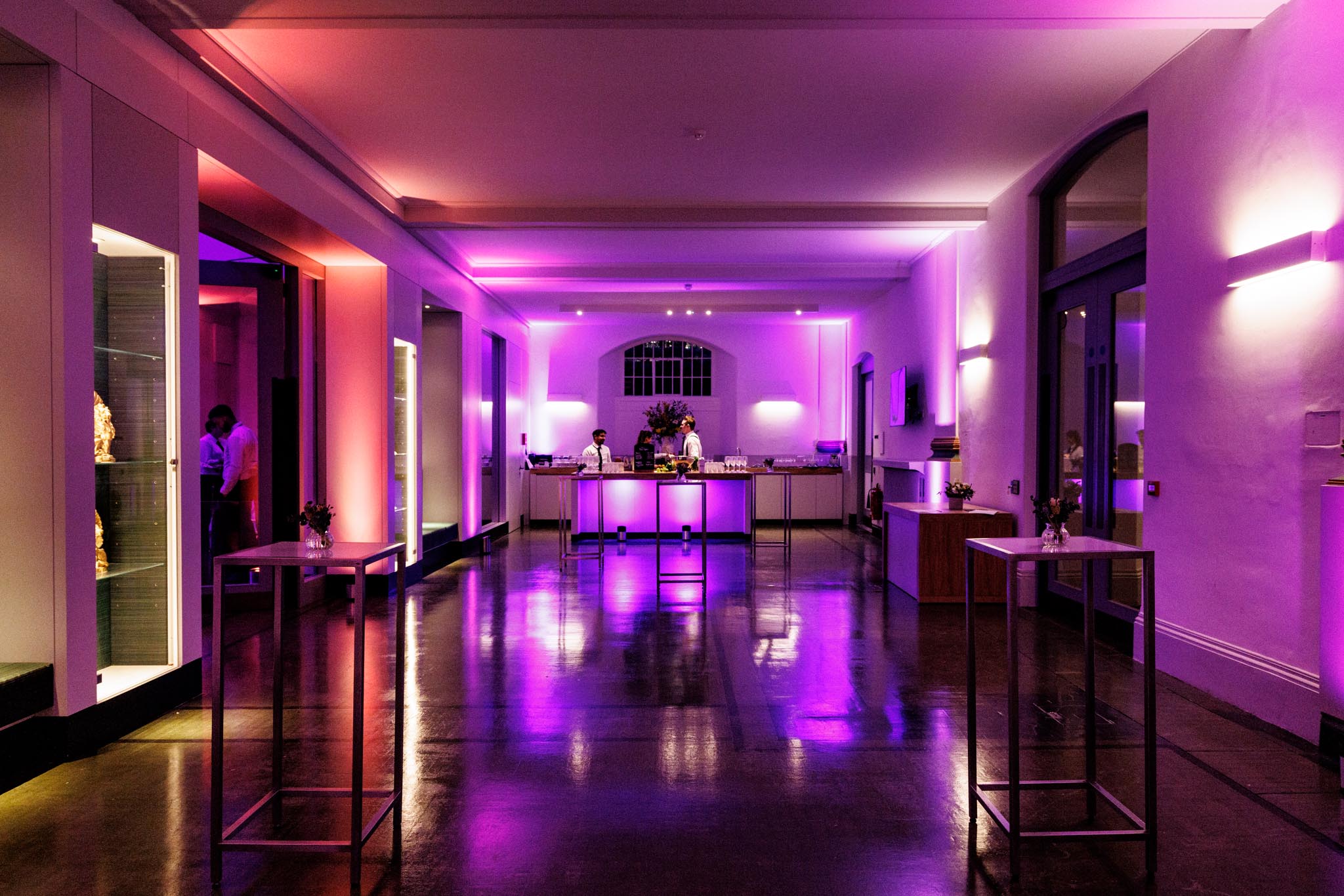 Stylish event space with purple lighting, ideal for receptions and cocktail events. - Banner