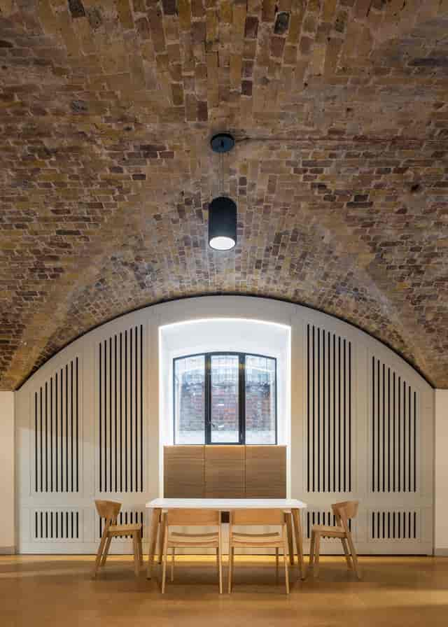 Stylish event space with arched brick ceiling, perfect for corporate meetings and social gatherings.