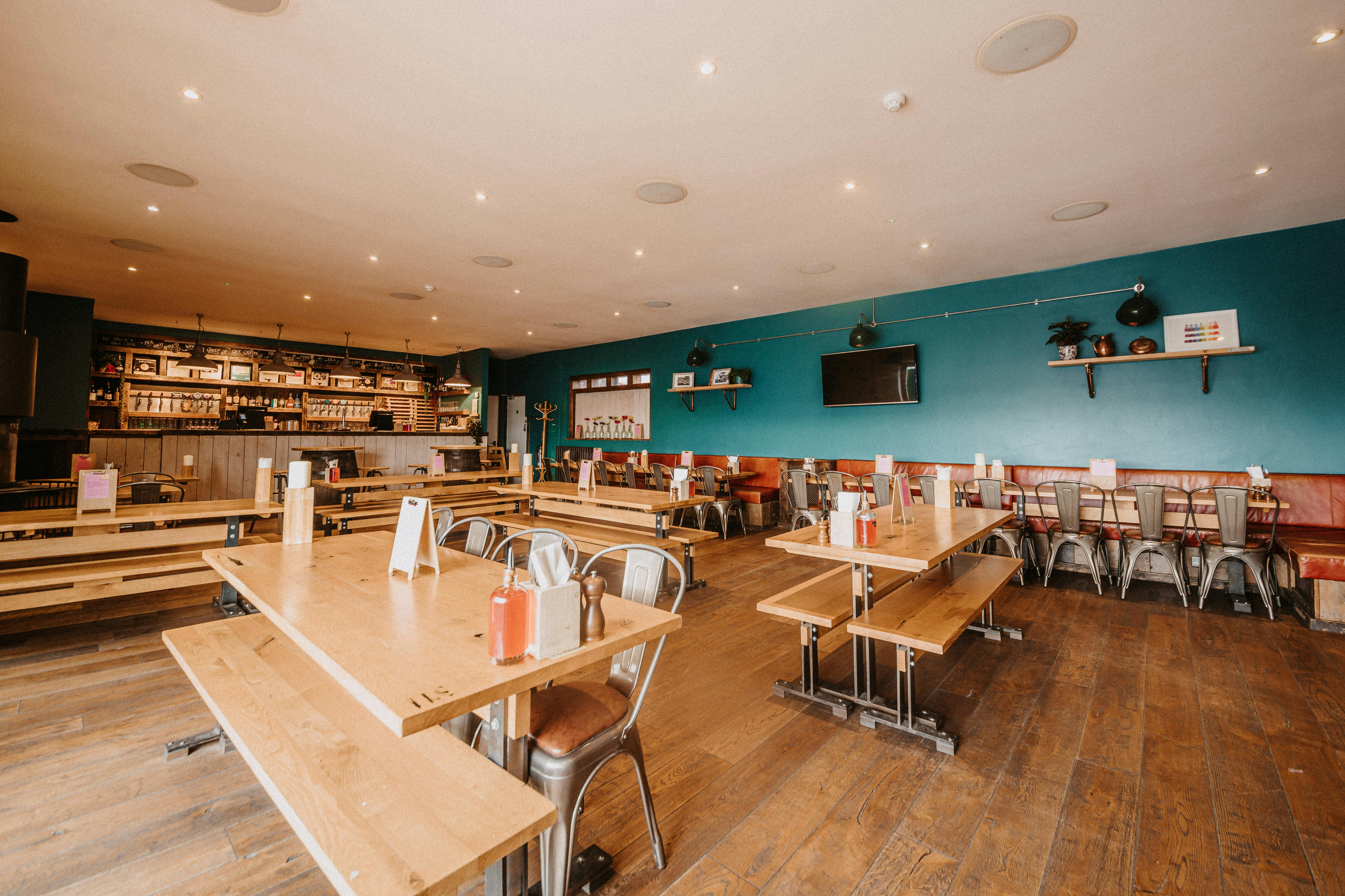 Spacious Top Deck venue with blue accent wall, ideal for casual gatherings and networking events.