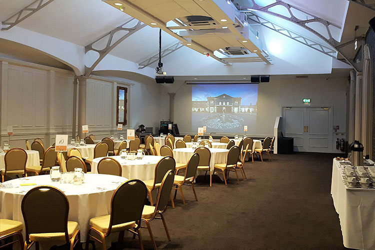Grand Station Conference venue with round tables set for meetings and presentations.