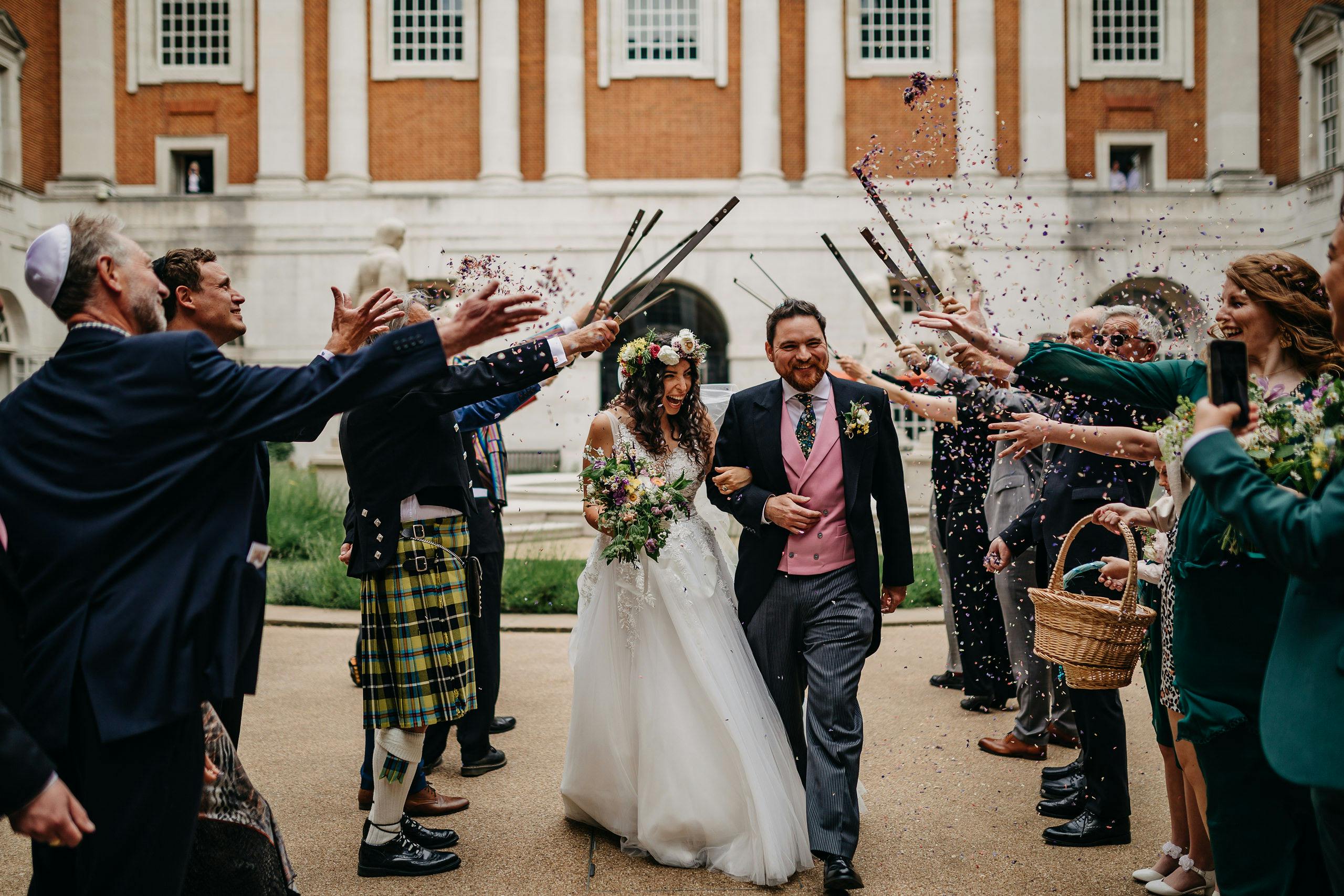 Joyful wedding celebration at BMA House with confetti and elegant architecture.