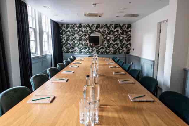Meeting room with wooden table, floral wallpaper for corporate events and workshops.