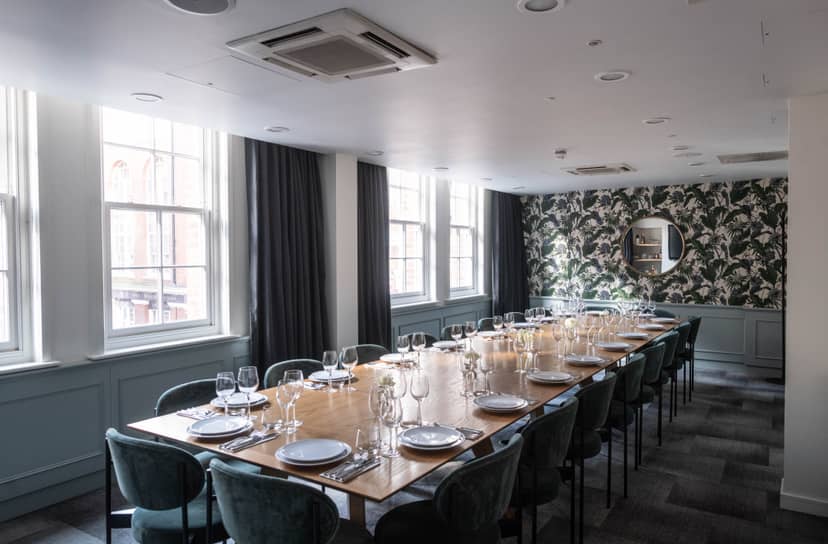 Stylish meeting room with wooden table, perfect for intimate gatherings and events.
