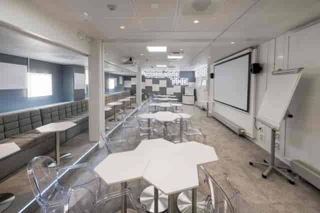 Modern meeting space with hexagonal tables for workshops and brainstorming sessions.